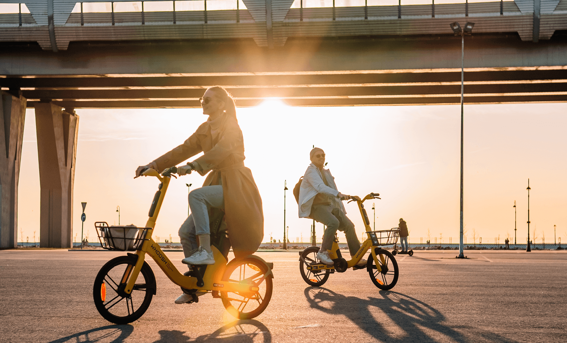 Две девушки на электровелосипедах на фоне рассвета